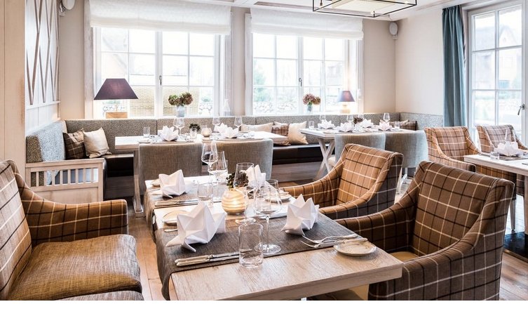 Speisesaal im Restaurant Hoog im Luxus Hotel Severin*s auf Sylt Elegantes Restaurant mit gedeckten Tischen, bequemen Sesseln und großen Fenstern im Severin*s Resort & Spa, Sylt.