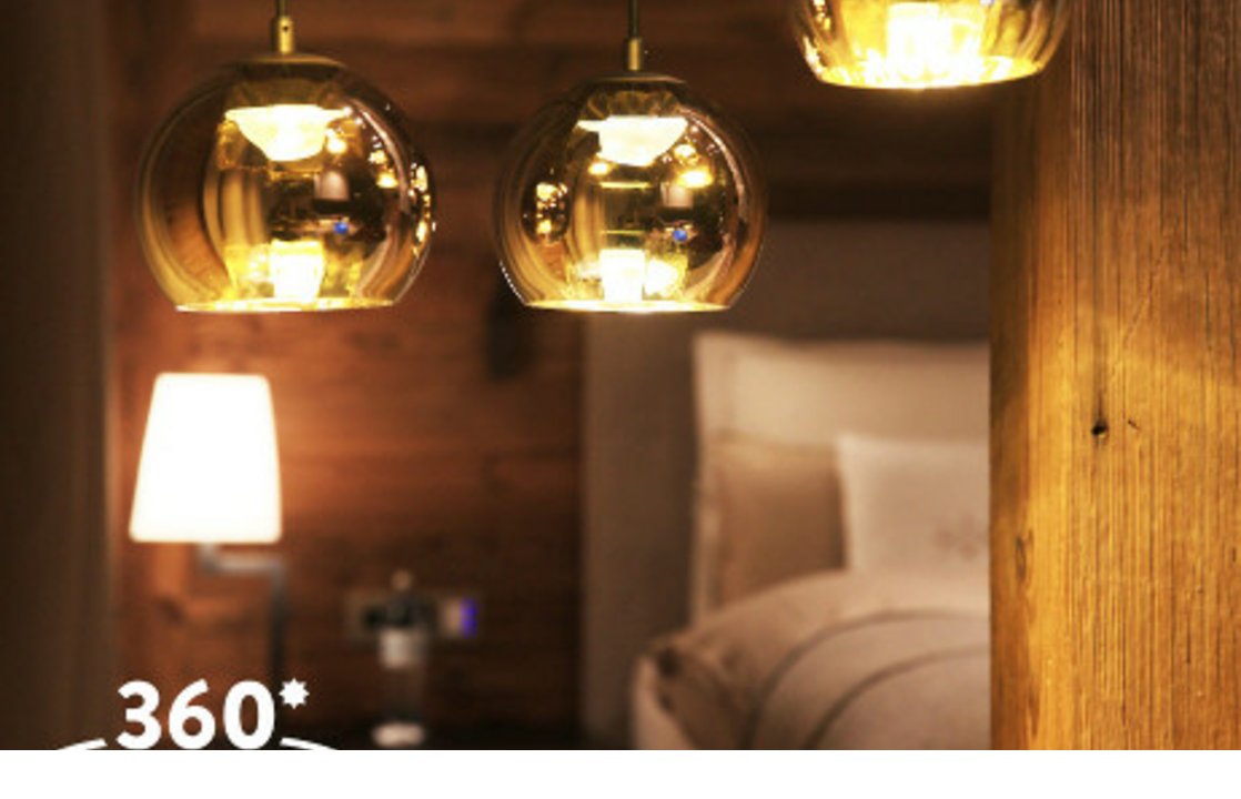 Gemütliches Hotelzimmer mit Holzverkleidung, modernen Hängelampen und einem einladenden Bett im Severin*s The Alpine Retreat.