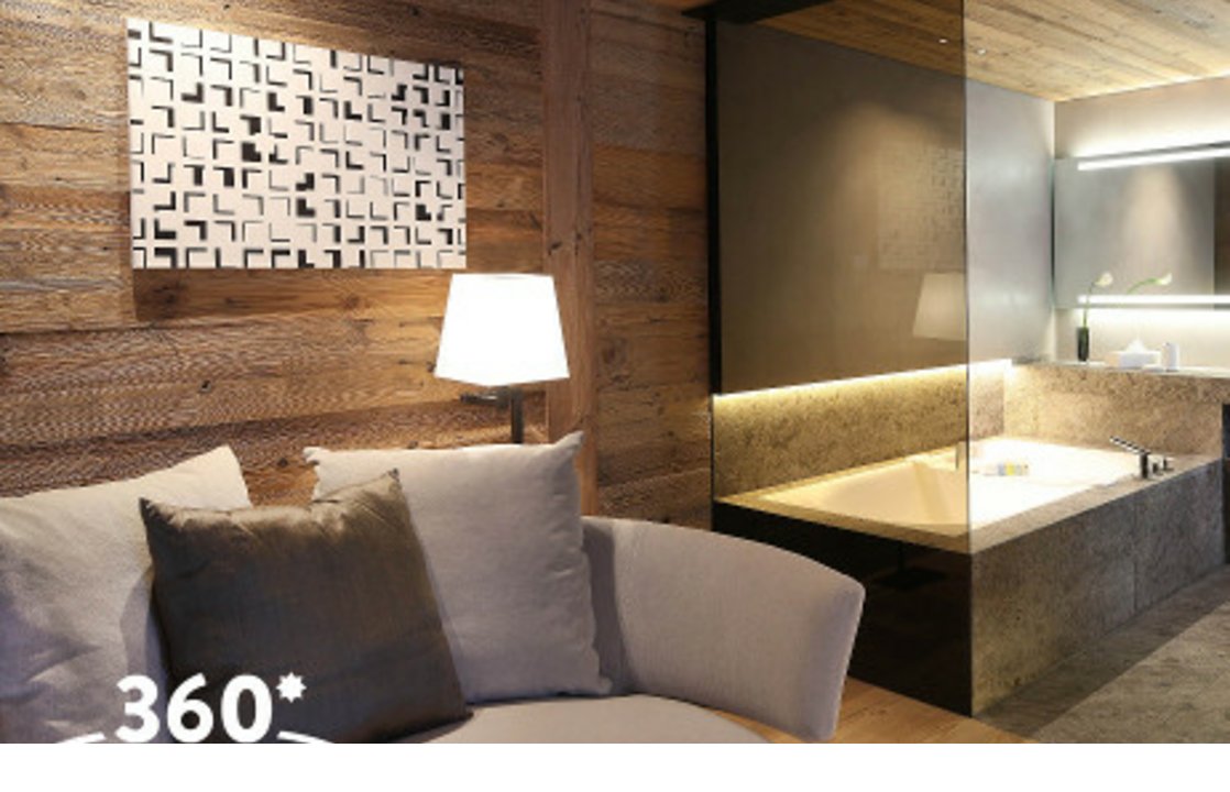 Gemütliche Suite mit Holzverkleidung, moderner Kunst, Sofa und luxuriösem Bad im Hotel Severin*s The Alpine Retreat, Lech.