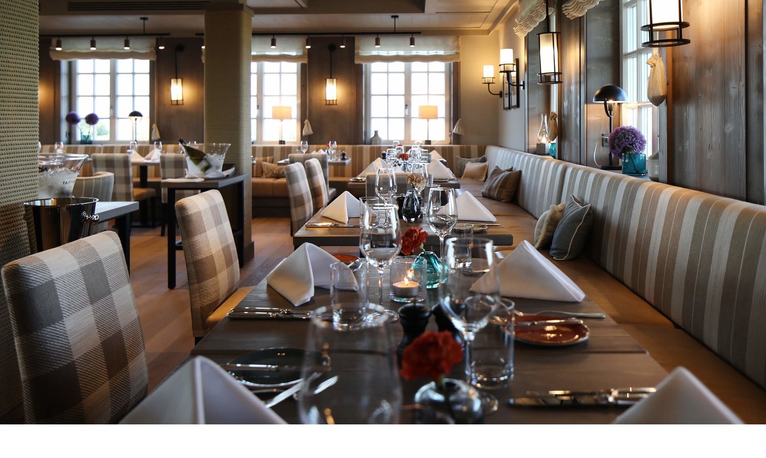 Restaurant Landhaus Severin*s Morsum Kliff Elegantes Restaurant mit gedeckten Tischen, gemütlichen Sitzbänken und warmem Licht im Hotel Landhaus Severin*s Morsum Kliff.