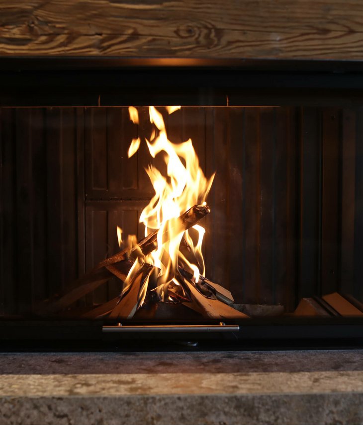 Gemütliches Kaminfeuer in modernem, hölzernem Ambiente des Severin*s The Alpine Retreat in Lech.