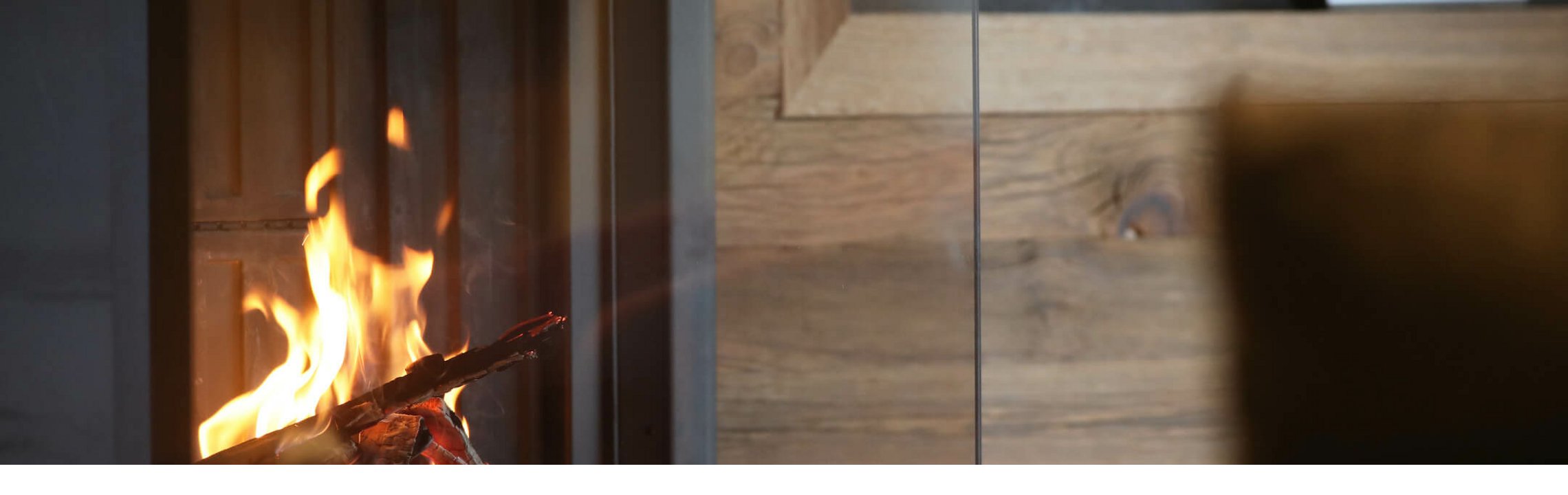 Gemütliches Kaminfeuer im Severin*s The Alpine Retreat, umgeben von eleganten Holzwänden.