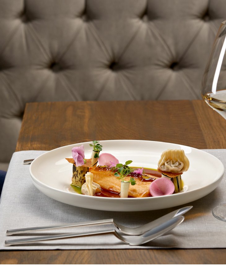 Ein Gourmetgericht und ein Glas Weißwein im Severin*s The Alpine Retreat in Lech.