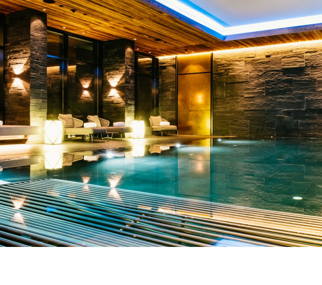 Luxuriöser Innenpool mit gemütlichen Liegen und sanfter Beleuchtung im Hotel Severin*s The Alpine Retreat.