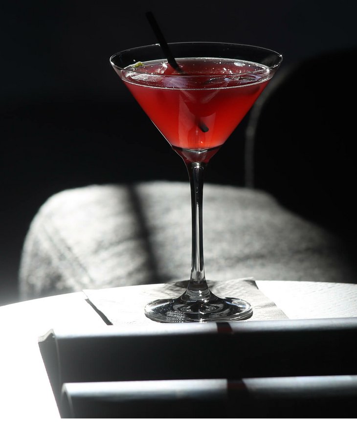 Hotelbar im Severin*s - The Alpine Retreat Roter Cocktail auf einem Tisch im Hotel Severin*s The Alpine Retreat in Lech, elegant beleuchtet.