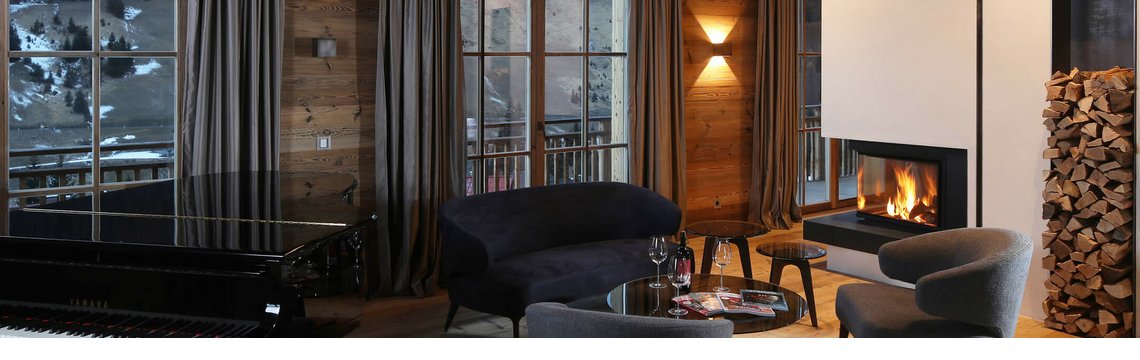 Wohnbereich mit Klavier und Kamin in der Residence des Hotels Severin*s – The Alpine Retreat in Lech
