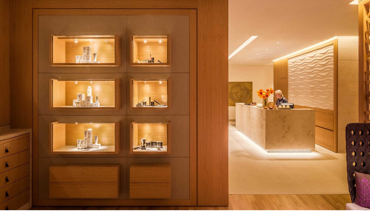 Elegante Hotelrezeption mit beleuchteter Vitrine und warmem, einladendem Ambiente im Severin*s Resort & Spa auf Sylt.