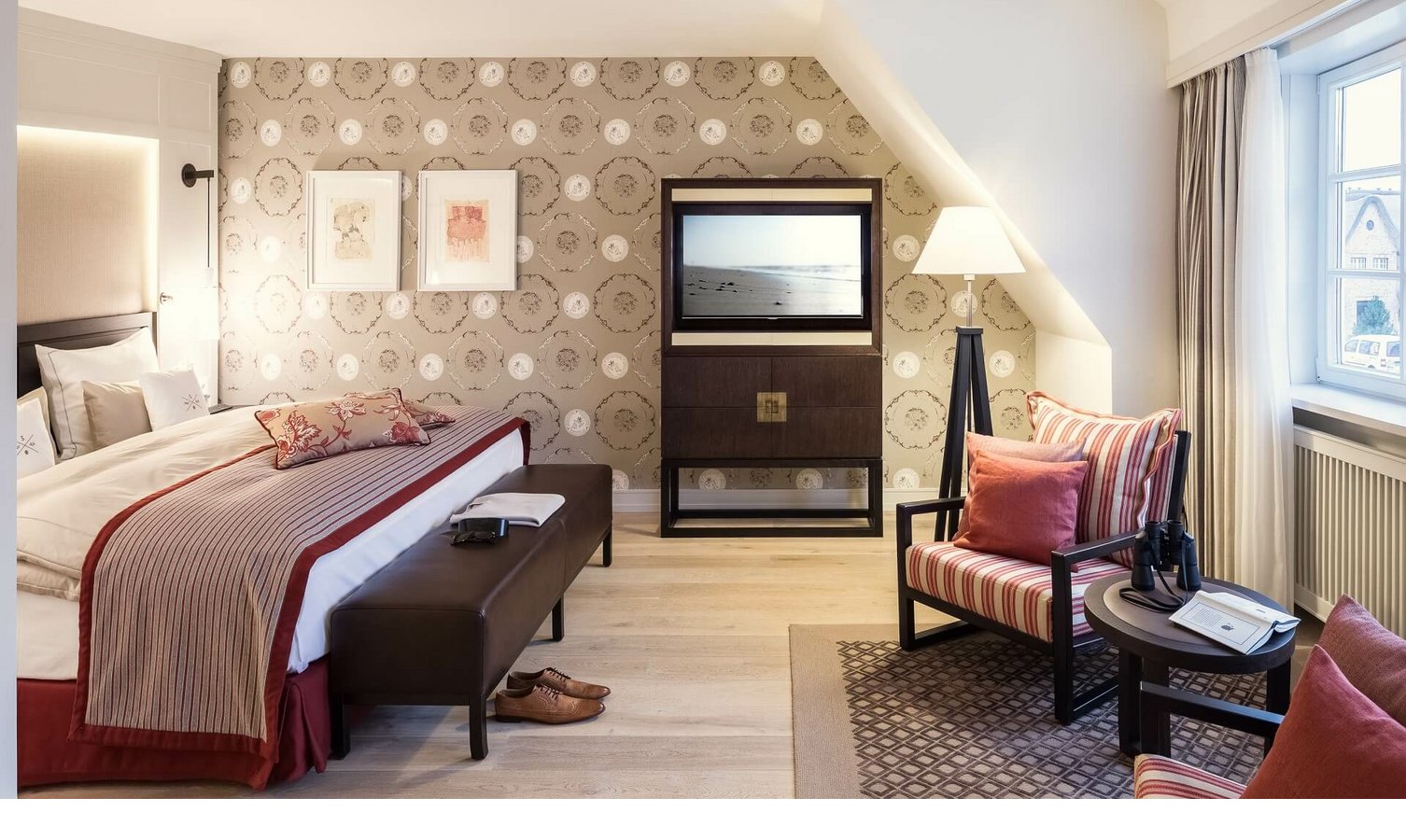 Superior Doppelzimmer im Severin*s Resort & Spa auf Sylt Elegantes Hotelzimmer mit Doppelbett, stilvoller Tapete, gemütlicher Sitzecke und großem Fenster im Severin*s Resort & Spa.