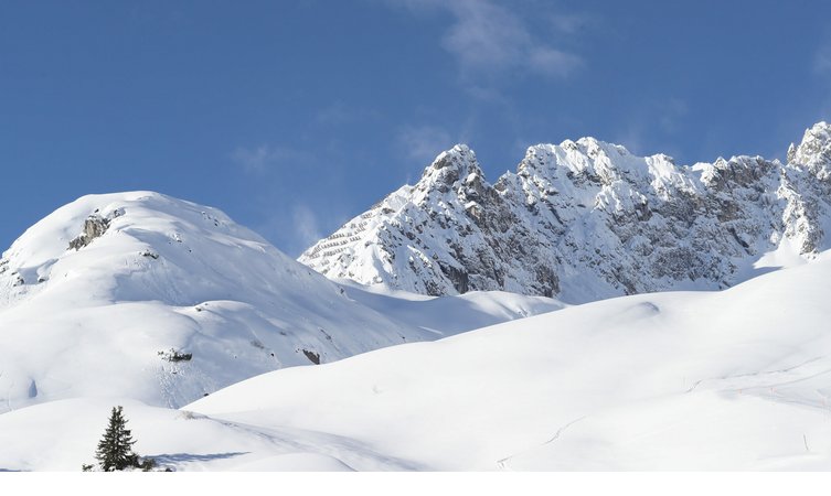 Skigebiet rund um das Severin*s – The Alpine Retreat Schneebedeckte Alpenlandschaft mit blauem Himmel, ideal für Wintersport, nahe Hotel Severin*s The Alpine Retreat in Lech.
