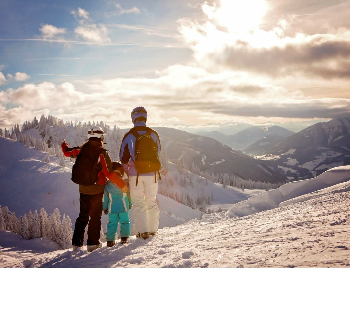 Familie im Schnee in den Bergen | Severin*s The Alpine Retreat Familie in Skiausrüstung genießt winterliche Berglandschaft bei Sonnenuntergang.