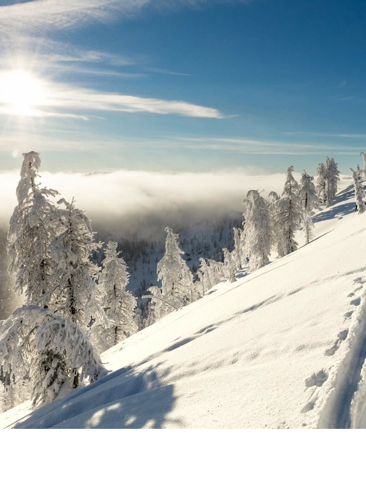 Verschneite Berglandschaft mit Skitourengehern unter strahlendem Sonnenschein beim Hotel Severin*s The Alpine Retreat.