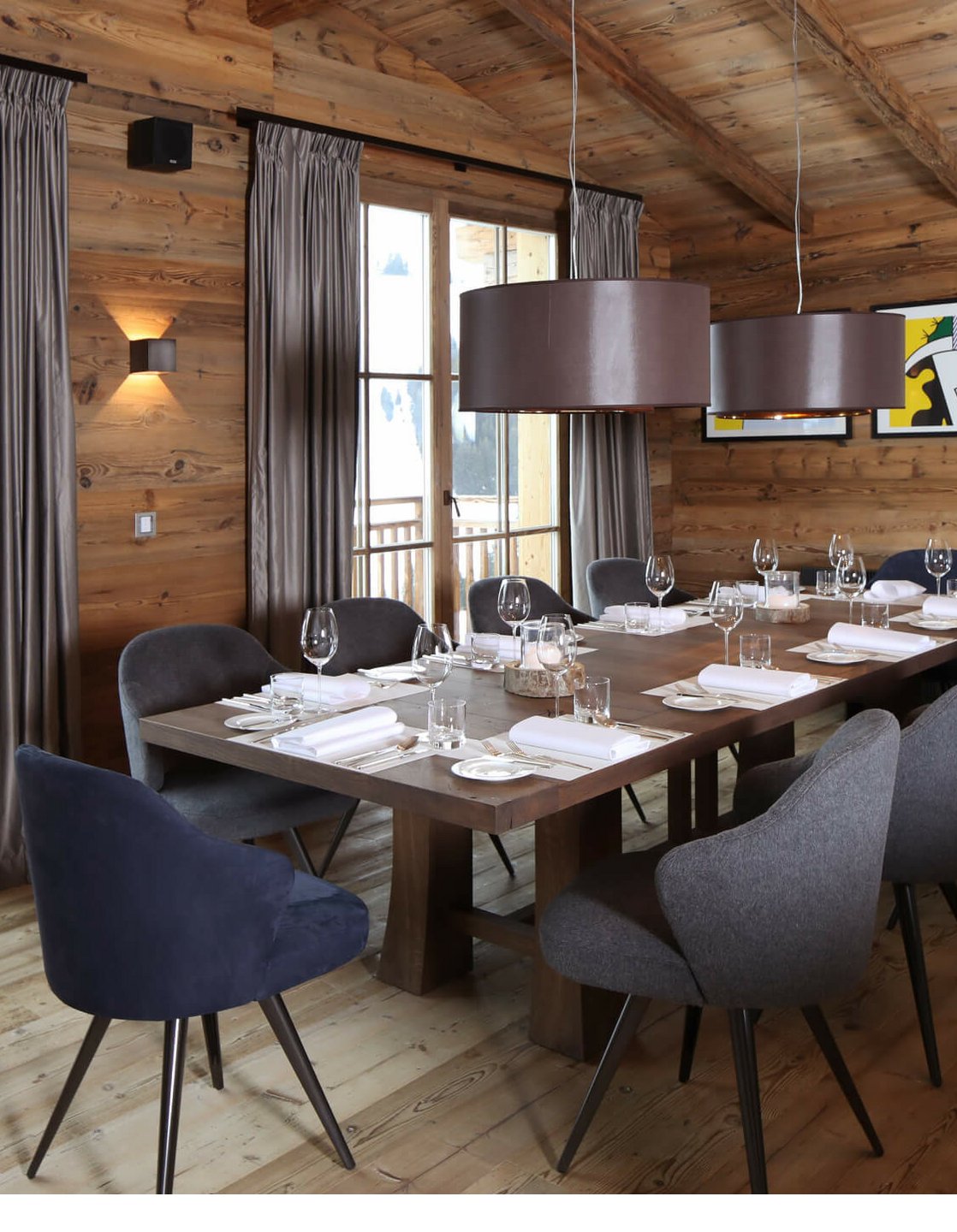 Gemütlicher Speiseraum mit Holzwänden, elegant gedecktem Tisch und Bergblick durch große Fenster im Severin*s The Alpine Retreat.